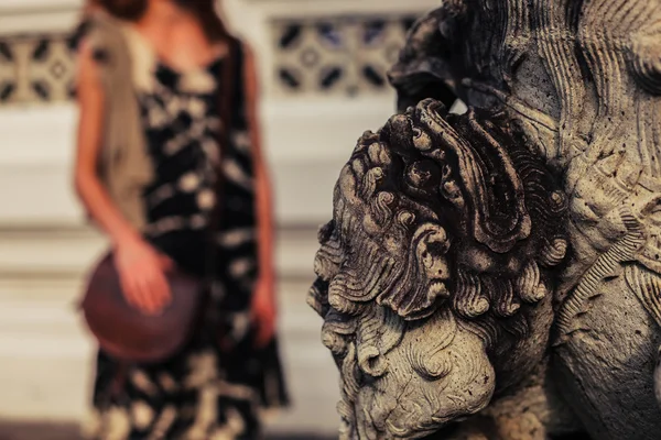 Buddhist statue with woman in background — Stock Photo, Image