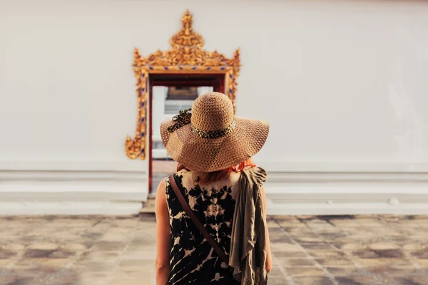Kvinne som ser på dører til buddhistisk tempel – stockfoto