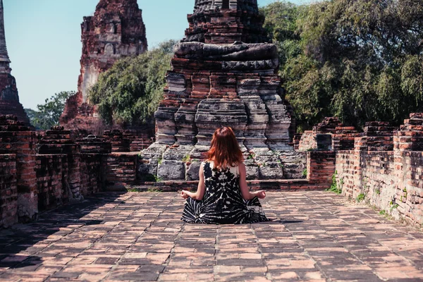 Woman meditating in ancient ruins — Stock Photo, Image