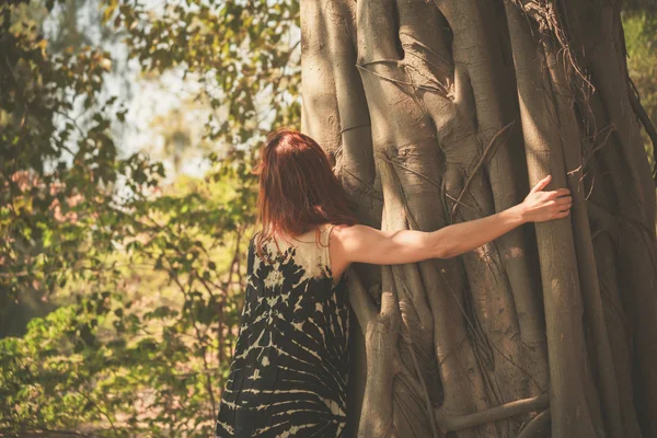 Kvinna som kramar en jätte träd — Stockfoto