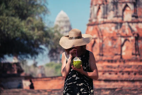 Donna che beve succo di cocco da tempio antico — Foto Stock