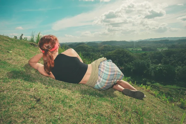 Woman lying on hillside and admiring view — Stock Photo, Image