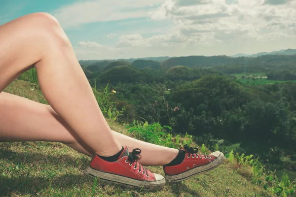 Nogi młoda kobieta relaksujący na wzgórzu — Zdjęcie stockowe