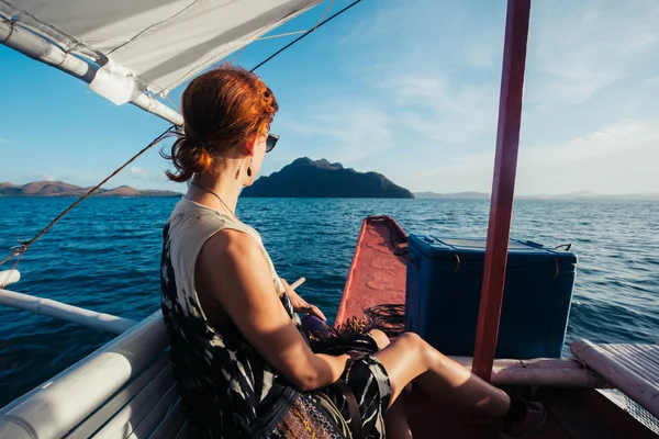 Vrouw op boot nadert tropisch eiland — Stockfoto