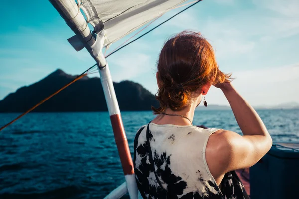 Vrouw op boot nadert tropisch eiland — Stockfoto