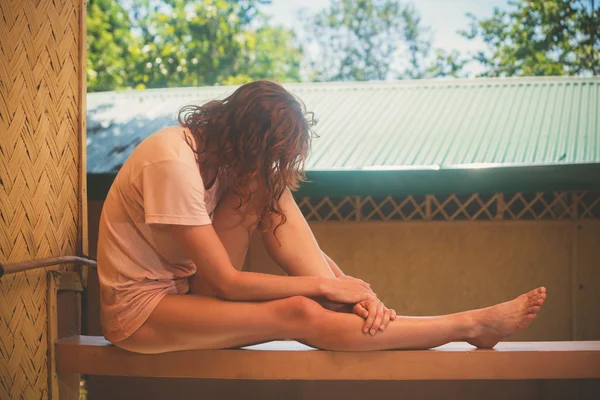 Jonge vrouw ontspannen op de veranda — Stockfoto