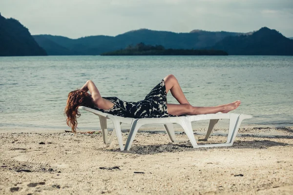 Mujer relajándose en la cama de sol en los trópicos — Foto de Stock