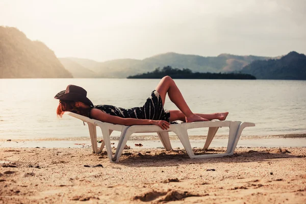 Mulher relaxante no leito solar nos trópicos — Fotografia de Stock