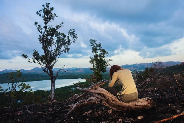 Triste joven sentada en una colina quemada —  Fotos de Stock