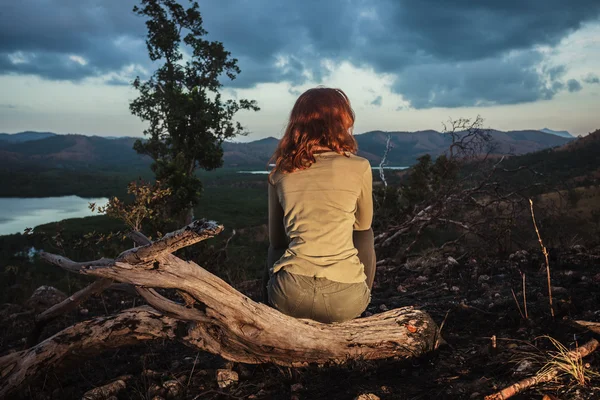 Vrouw zitten op een verbrande heuvel — Stockfoto