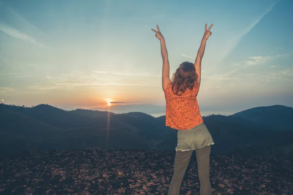 Woman watching sunrise over mountains — Stock Photo, Image