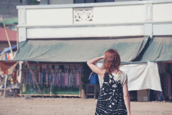 Mujer joven caminando en un pequeño pueblo en un país en desarrollo —  Fotos de Stock