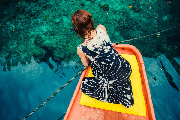 Γυναίκα σε βάρκα εξετάζοντας καθαρά μπλε νερά — Φωτογραφία Αρχείου