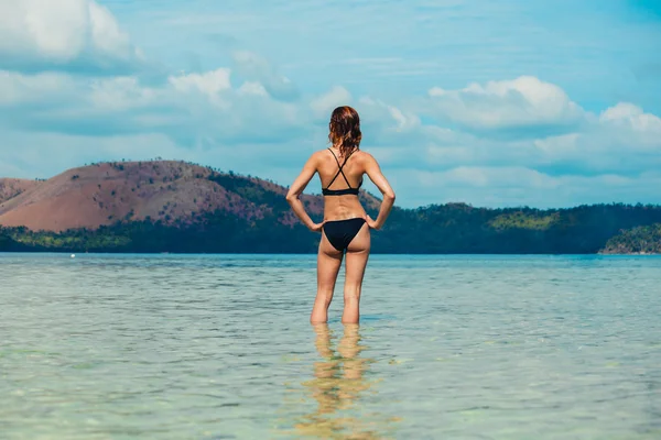 Woman standing in water by tropical beach — Stock Photo, Image