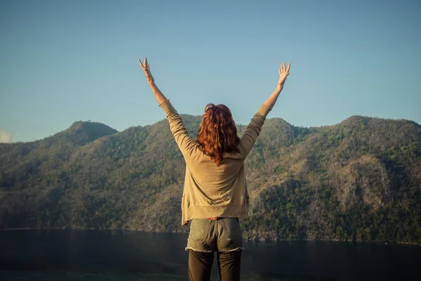 Mujer levantando los brazos en la cima de la montaña — Foto de Stock