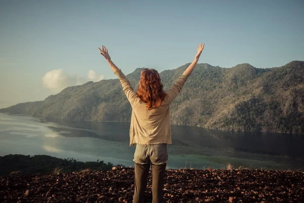 Mujer levantando los brazos en la cima de la montaña — Foto de Stock