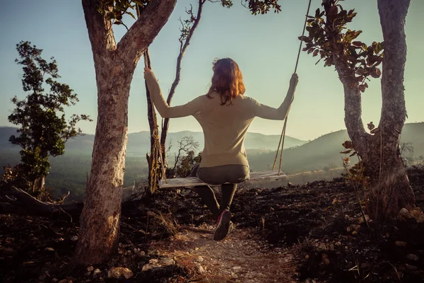 Jovem mulher em balanço na montanha — Fotografia de Stock