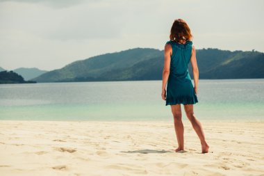 Tropik sahilde yürüyen genç kadın