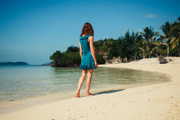 Νεαρή γυναίκα το περπάτημα σε τροπική παραλία — Φωτογραφία Αρχείου