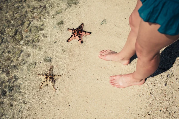 Dos estrellas de mar y los pies de una joven — Foto de Stock