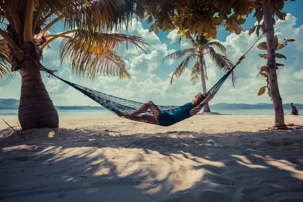 Mujer relajante en hamaca en playa tropical — Foto de Stock