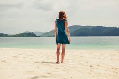 Tropik sahilde yürüyen genç kadın