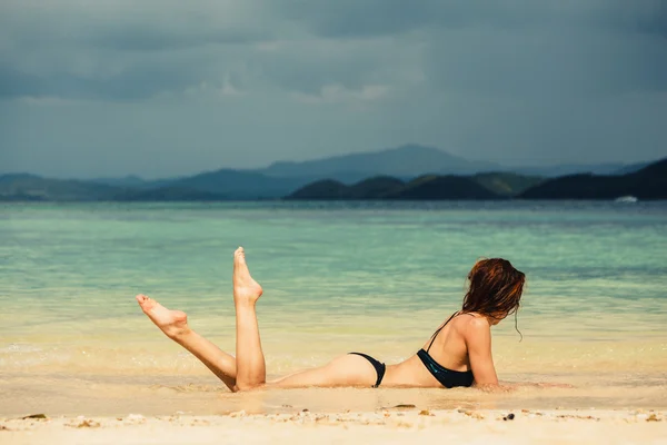 Sexy giovane donna sdraiata sulla spiaggia — Foto Stock