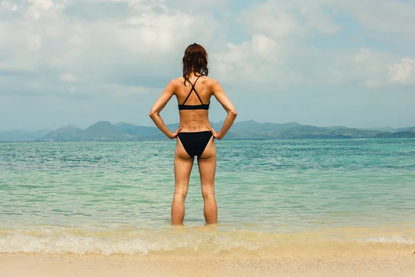 Sexy young woman standing on tropical beach — Stock Photo, Image