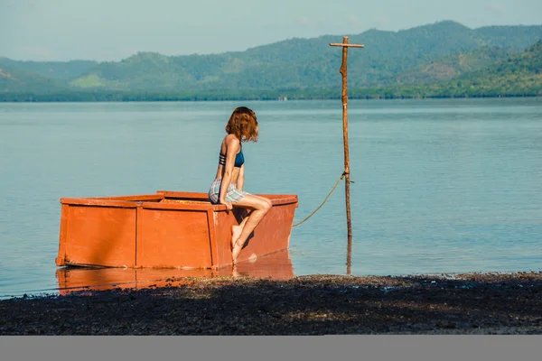 Vrouw zitten in de boot op strand — Stockfoto