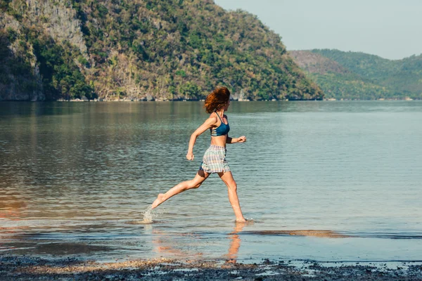 ผู้หญิงวิ่งบนชายหาดเขตร้อน — ภาพถ่ายสต็อก