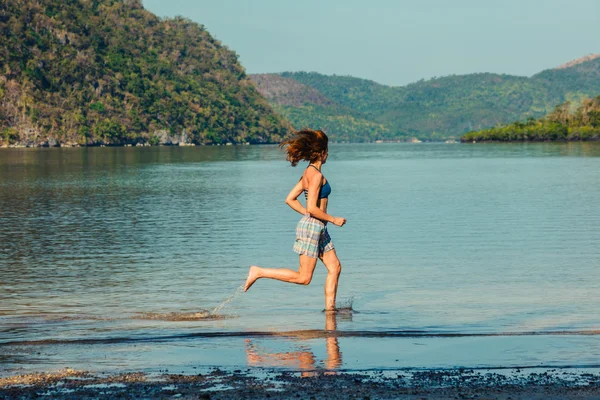 Donna che corre sulla spiaggia tropicale — Foto Stock