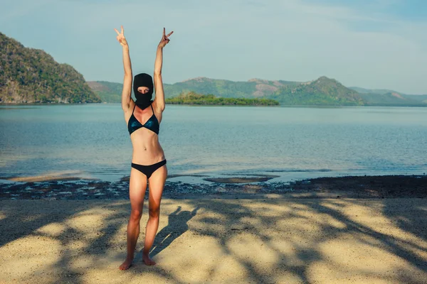 Kvinna iklädd bikini och balaclava på stranden — Stockfoto