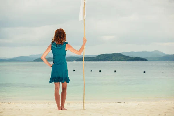 Woman on tropical beach with flag — Stock Photo, Image