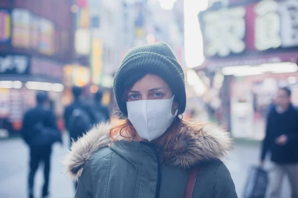 Mladá žena s obličejovou maskou v Japonsku — Stock fotografie
