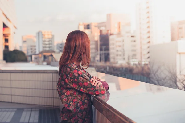 Frau blickt auf Skyline bei Sonnenuntergang — Stockfoto