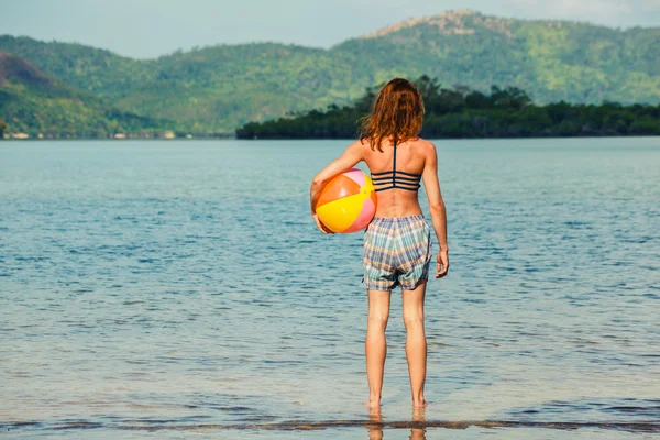 Mulher com bola de praia na praia — Fotografia de Stock