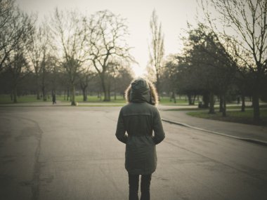 Sıcak palto ayakta parkta günbatımında giyen kişi