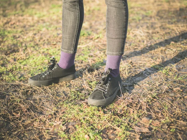 Benen toetsen oen voeten van persoon permanent op het gras — Stockfoto