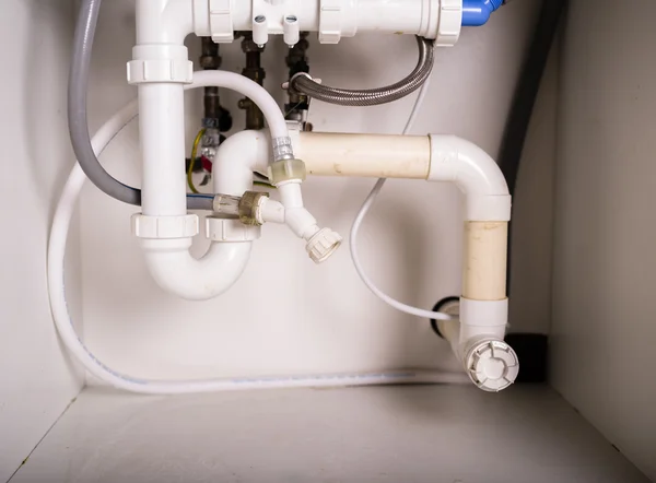 Pipes and plumbing under sink — Stock Photo, Image