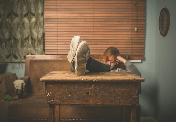 Женщина отдыхает ногами на столе — стоковое фото