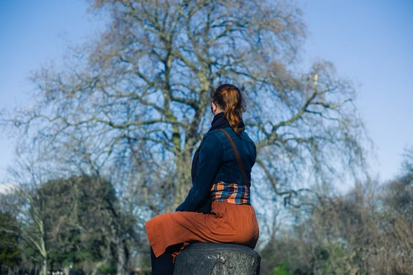 Vrouw zitten op een boomstam — Stockfoto