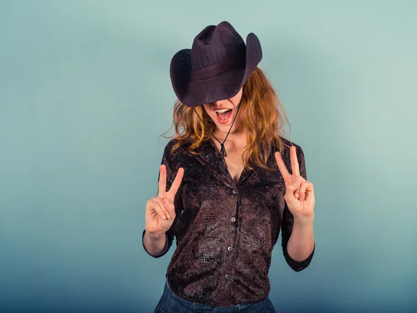 Vrouw met cowboy hoed vredesteken tonen — Stockfoto