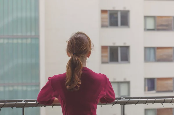 Mujer de pie en el balcón del apartamento — Foto de Stock