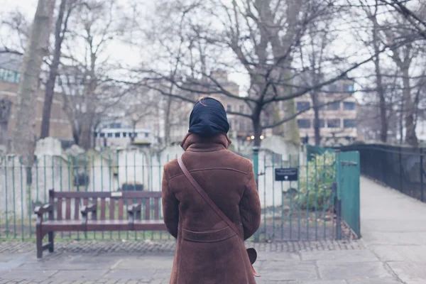 Kvinnan promenader runt en kyrkogård — Stockfoto