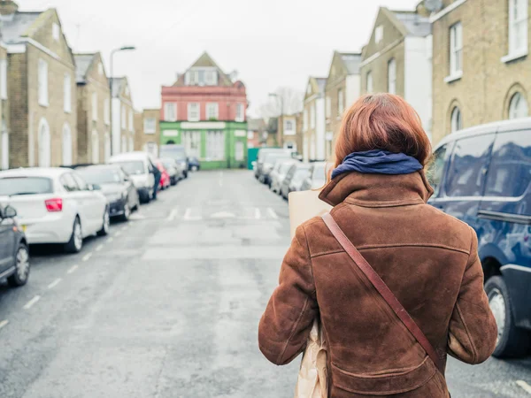 Jeune femme marchant dans la rue — Photo