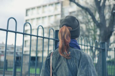 Sokakta yürüyen genç bir kadın.