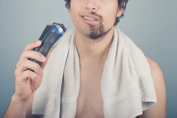 Человек со сломанной бритвой не может закончить бритье — стоковое фото