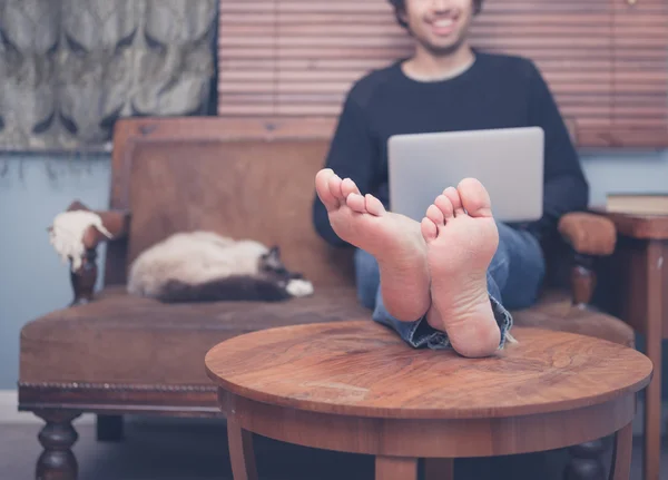 Barefoot man aan het werk op laptop — Stockfoto