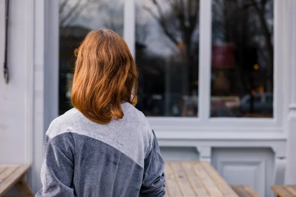 Junge Frau steht vor Kneipe — Stockfoto