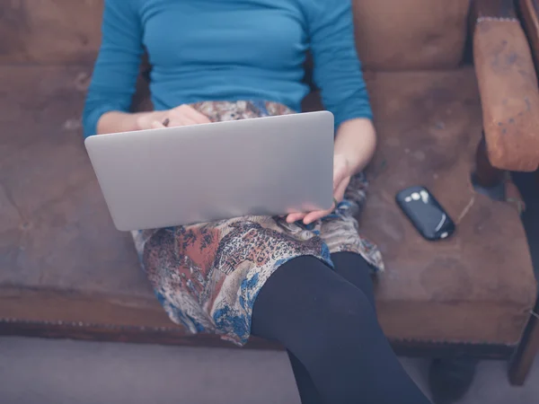 Jonge vrouw met laptop thuis — Stockfoto